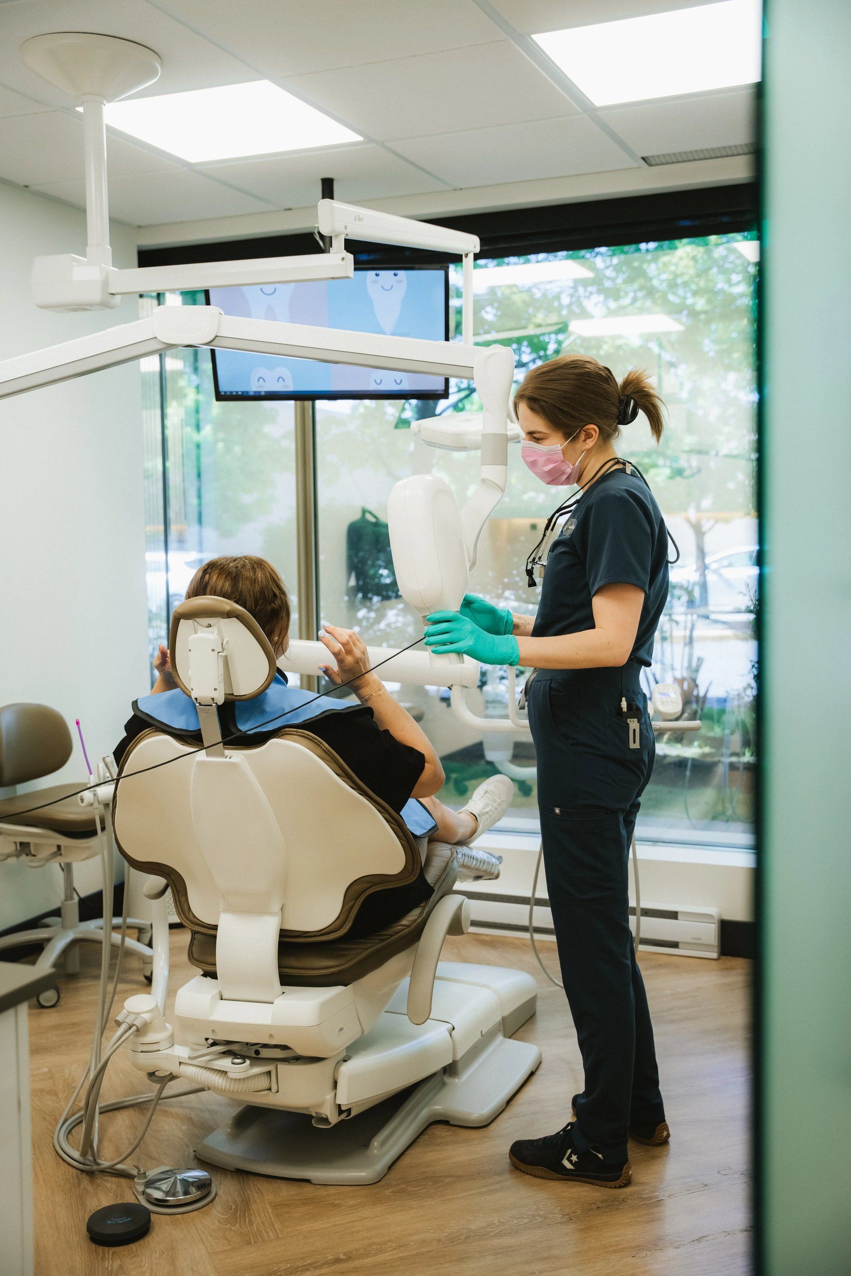 Hygiéniste dentaire préparant une patiente pour une radiographie panoramique en clinique