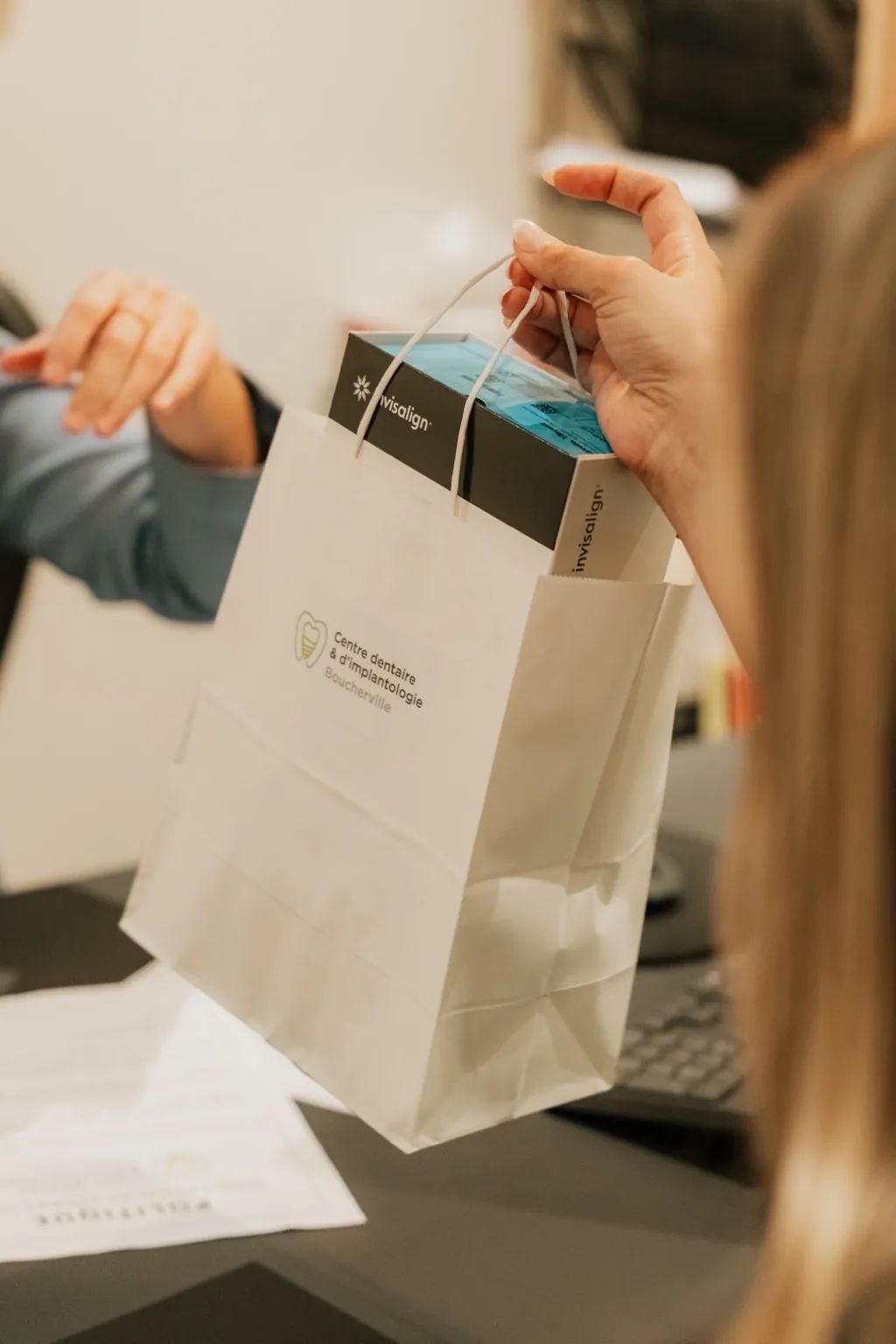 Patient recevant sa boîte Invisalign et son plan de traitement en clinique dentaire