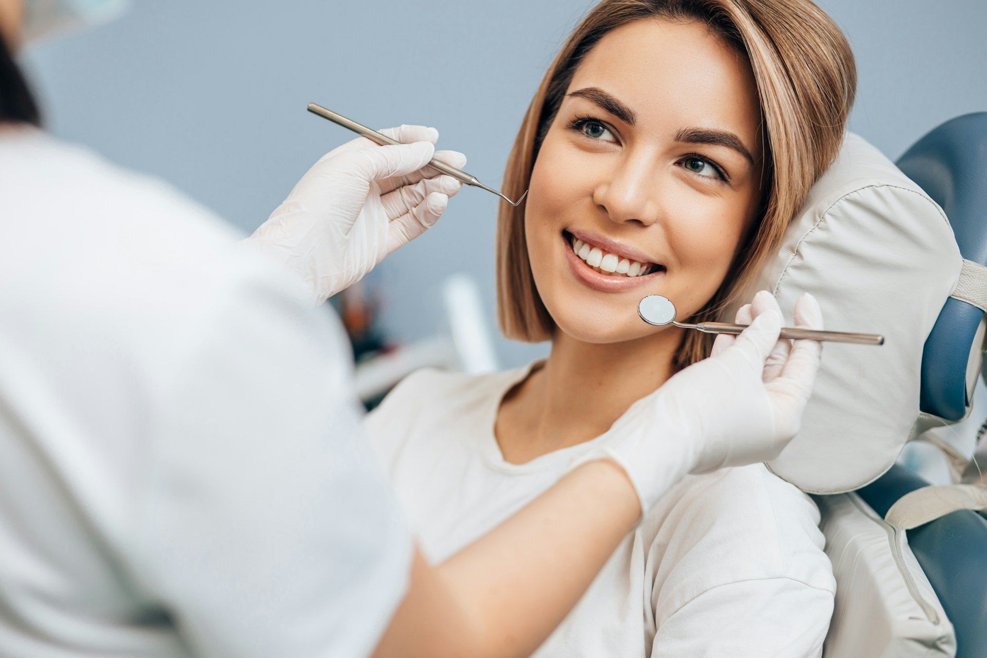 Dentiste examinant le sourire d’une patiente souriante