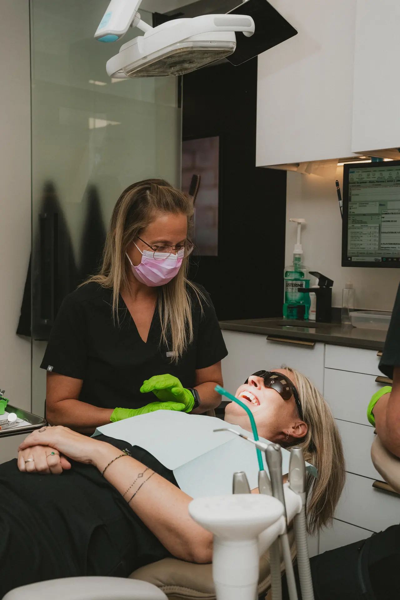 Membre du personnel dentaire souriant avec une patiente détendue en salle de traitement au Centre dentaire Boucherville